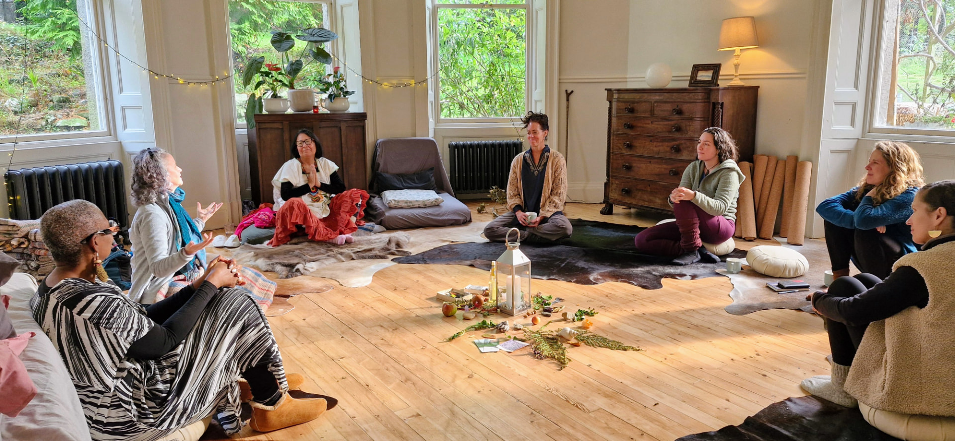Women of different ages sitting together in a circle in a light-filled room